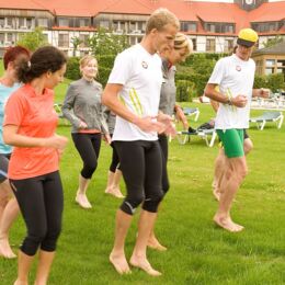 Sportgruppe läuft Barfuß in Gras